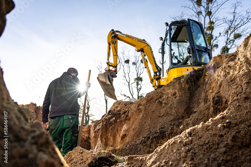 Fotobehang Excavation and earthwork at a construction site with a person and excavator