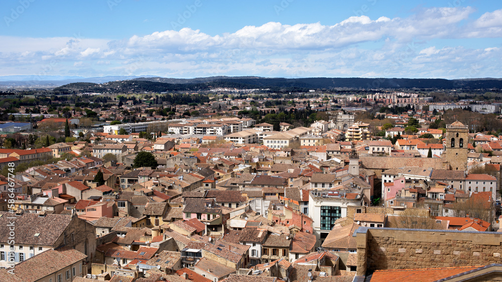 Ville du sud e la France avec vue sur les toits des maisons provençales et ruelles étroites et collines boisées en fond.