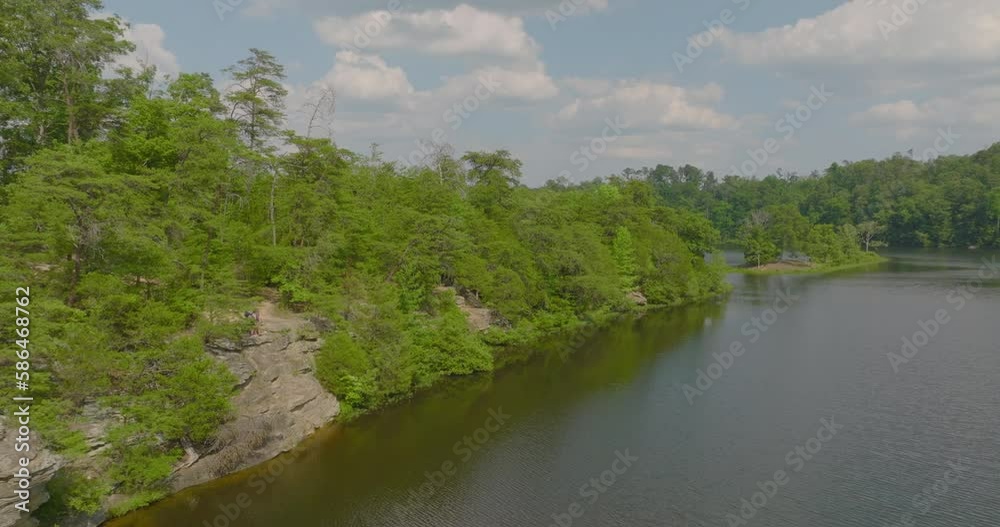 Aerial Panning Shot Of Tourists In Forest On Cliff At Vacation, Drone Ascending Backwards Over River - Tuscaloosa, Alabama Aerial Panning Shot Of Tourists In Forest On Cliff At Vacation, Drone Ascending Backwards Over River - Tuscaloosa, Alabama