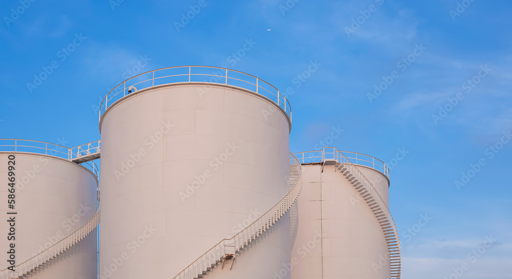 Three white Storage Fuel Tanks in Oil Industrial area against blue sky background, low angle view with copy space Three white Storage Fuel Tanks in Oil Industrial area against blue sky background, low angle view with copy space