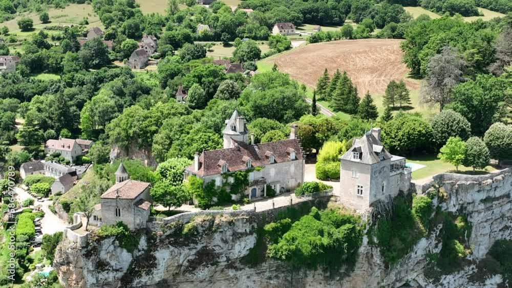 Droneshot of medieval castle on top of a big rock situated next to a river in France surrounded by dense forest. Droneshot of medieval castle on top of a big rock situated next to a river in France surrounded by dense forest.