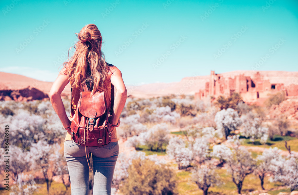 Naklejka premium Woman looking at panoramic view of moroccan countryside landscape in ben haddou near Ouarzazate