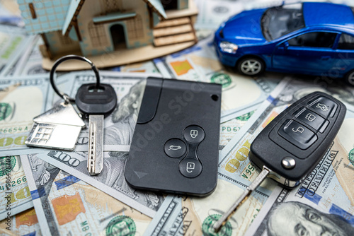 Keys of apartment house and car with us dollar bills money