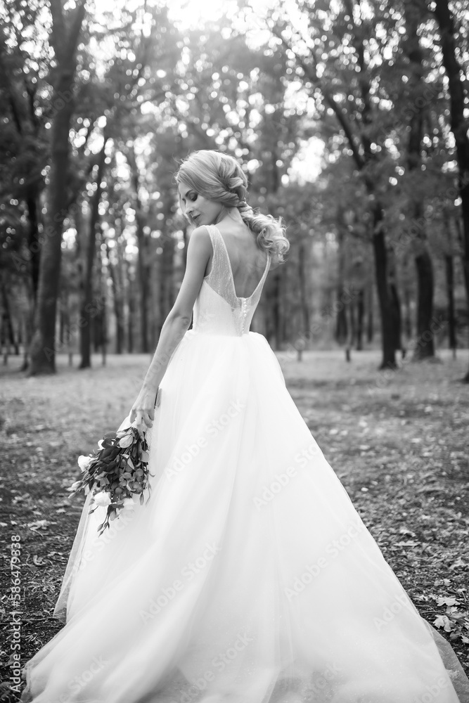 Black and white photo of Beautiful bride in a white dress for a walk in the park. Wedding day. Marriage. Fashion bride. Black and white photo of Beautiful bride in a white dress for a walk in the park. Wedding day. Marriage. Fashion bride.