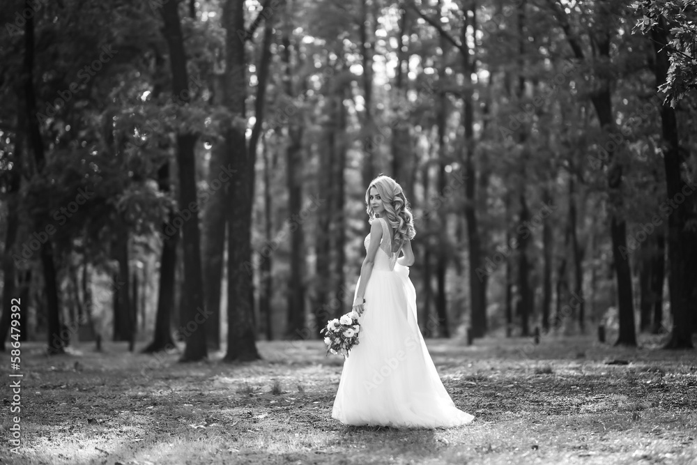Black and white photo of Beautiful bride in a white dress for a walk in the park. Wedding day. Marriage. Fashion bride. Black and white photo of Beautiful bride in a white dress for a walk in the park. Wedding day. Marriage. Fashion bride.