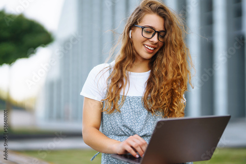 Young woman with laptop outdoor. Education online. Freelancer, Business, shopping, blogging.