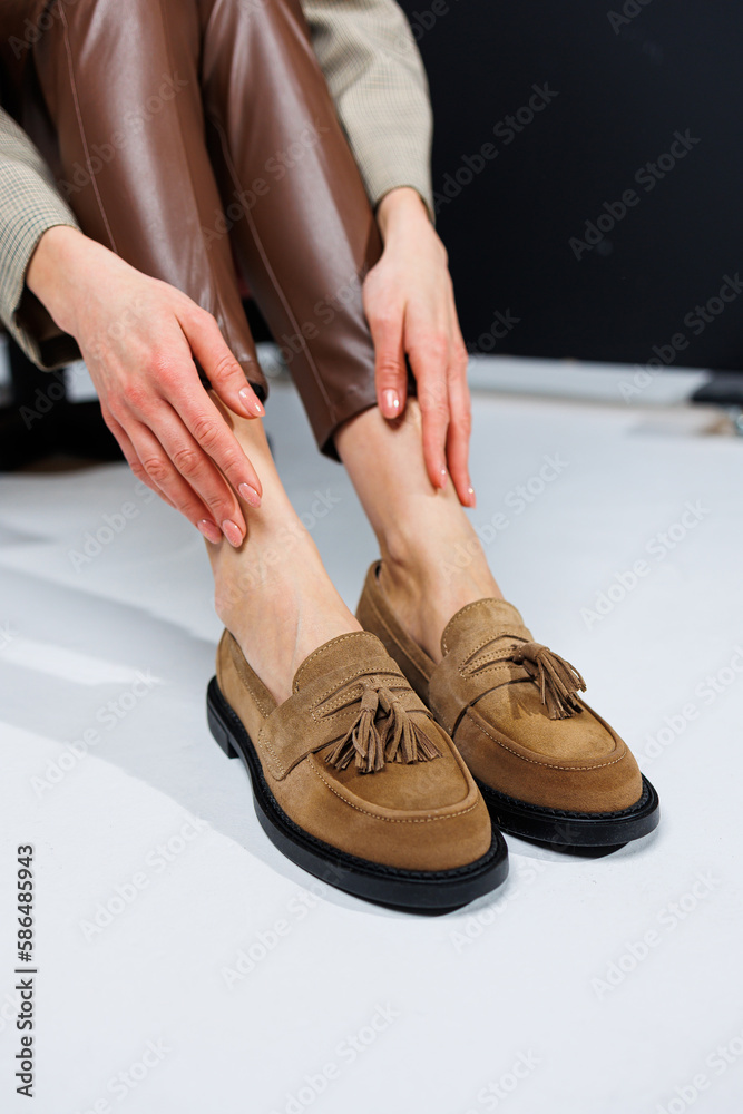 Casual women's fashion. Classic shoes for women. Slender female legs in trousers and brown stylish casual loafers. Women's comfortable summer shoes. Casual women's fashion. Classic shoes for women. Slender female legs in trousers and brown stylish casual loafers. Women's comfortable summer shoes.