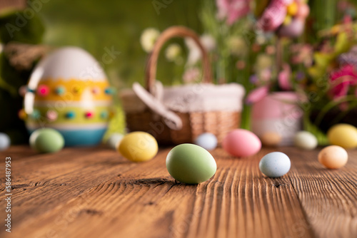 Easter theme. Easter decorations. Easter eggs in basket and easter bunny. Bouquet of spring flowers. Rustic wooden brown table.