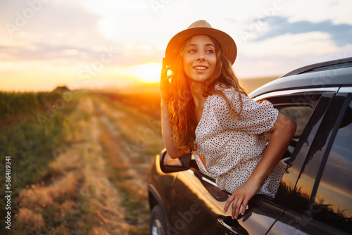 Relaxed happy woman on summer road trip travel vacation leaning out car window. Lifestyle, travel, tourism, nature, active life.