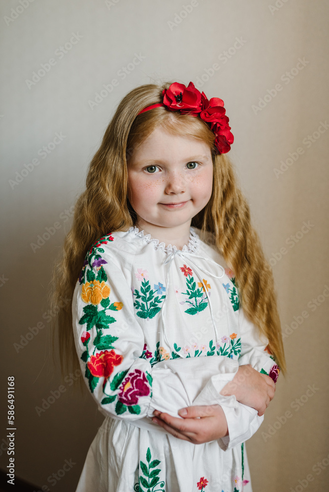 National ethnic traditional costume or dress. Portrait of a girl dressed in Ukrainian folk embroidered dress. A child with wreath of poppies on his head. Ukrainian girl, Ukrainian customs, traditions. National ethnic traditional costume or dress. Portrait of a girl dressed in Ukrainian folk embroidered dress. A child with wreath of poppies on his head. Ukrainian girl, Ukrainian customs, traditions.