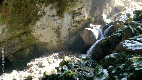 Push In Shot of The Stunning River Floating in Karst Cave, Secret Tunnel Located Under Predjama Castle, Surrounded With Moss on Stones and rocks. Predjama, Slovenia.