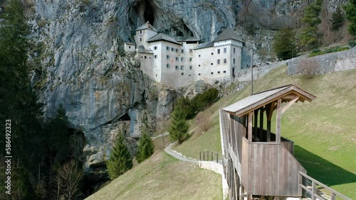 Orbit Around Most Fascinating, Historic Medieval Predjama Castle, Built Into Mouth Of a Cave, Under The Cliff. Popular Tourist Attraction With Knights Tournament Battlefield in Front of the Castle.