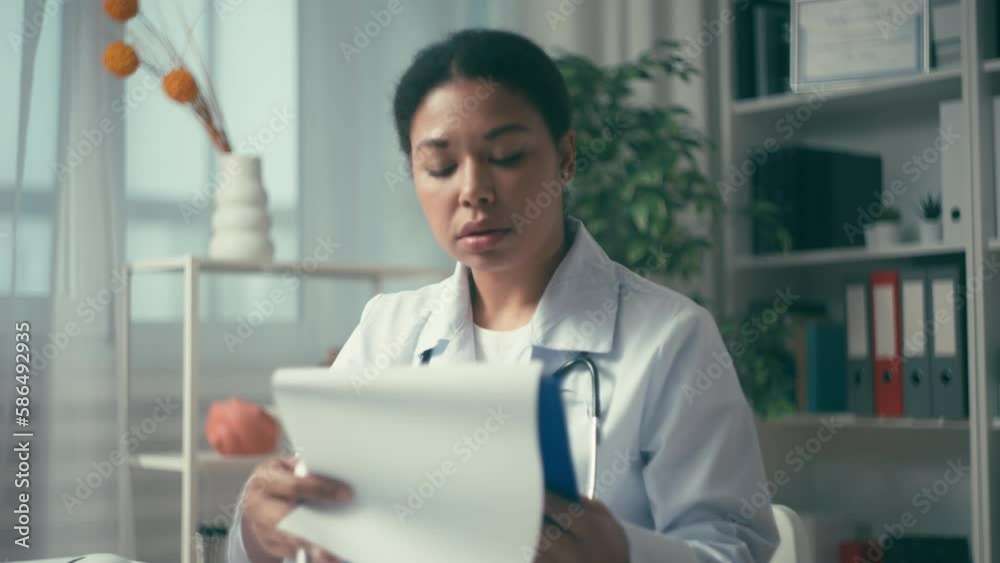Happy female doctor reading test results, talking to patient, recovery progress Happy female doctor reading test results, talking to patient, recovery progress