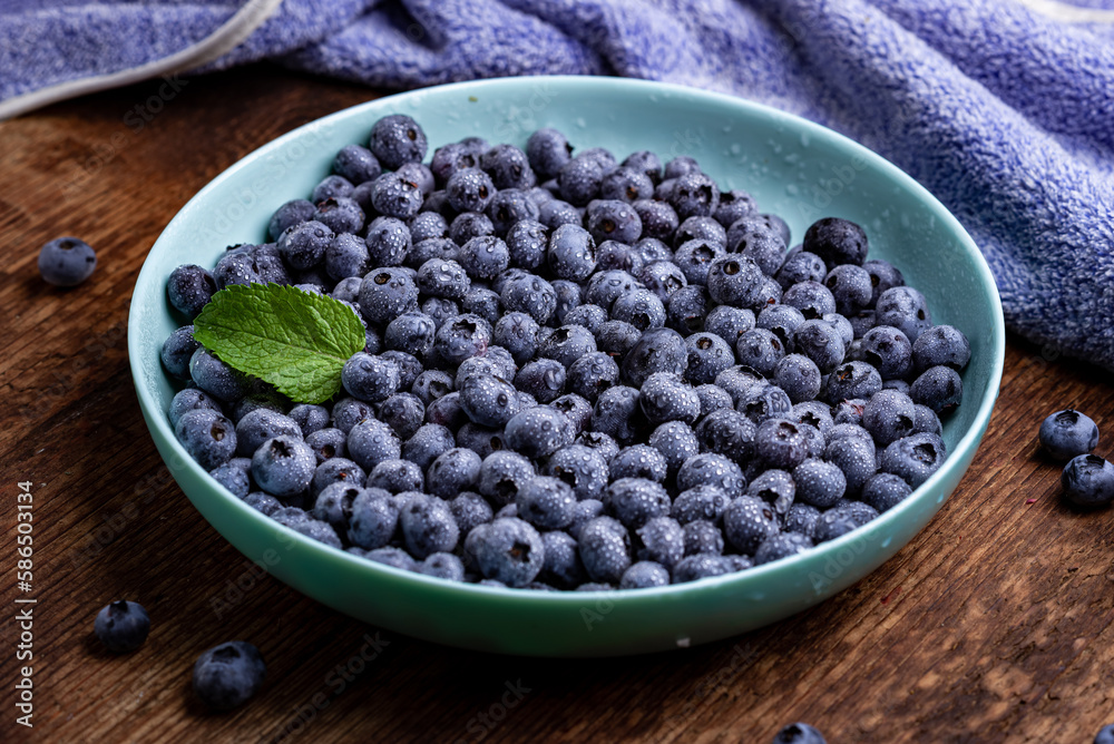 Fresh blueberries berries in a plate on a dark wooden background. Fresh blueberries berries in a plate on a dark wooden background.