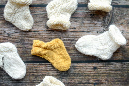Various styles handmade baby socks, on dark wooden background