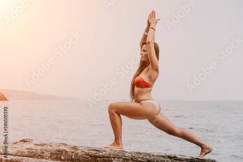 Woman sea yoga. Back view of free calm bliss satisfied woman with long hair standing on top rock with yoga position against of sky by the sea. Healthy lifestyle outdoors in nature, fitness concept.