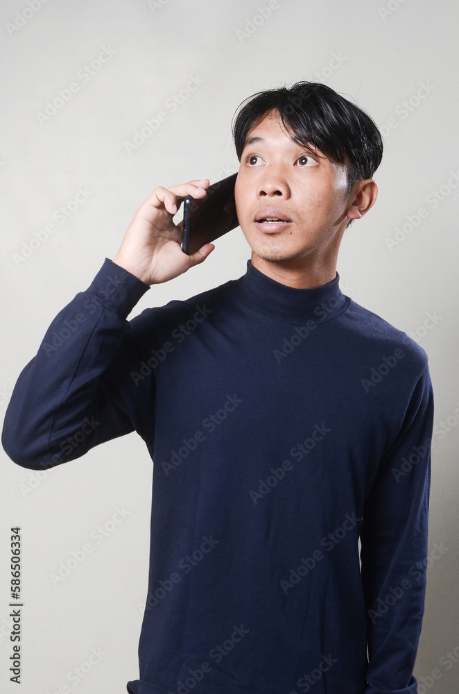 Happy Asian man using smartphone isolated on background. Happy Asian man using smartphone isolated on background.