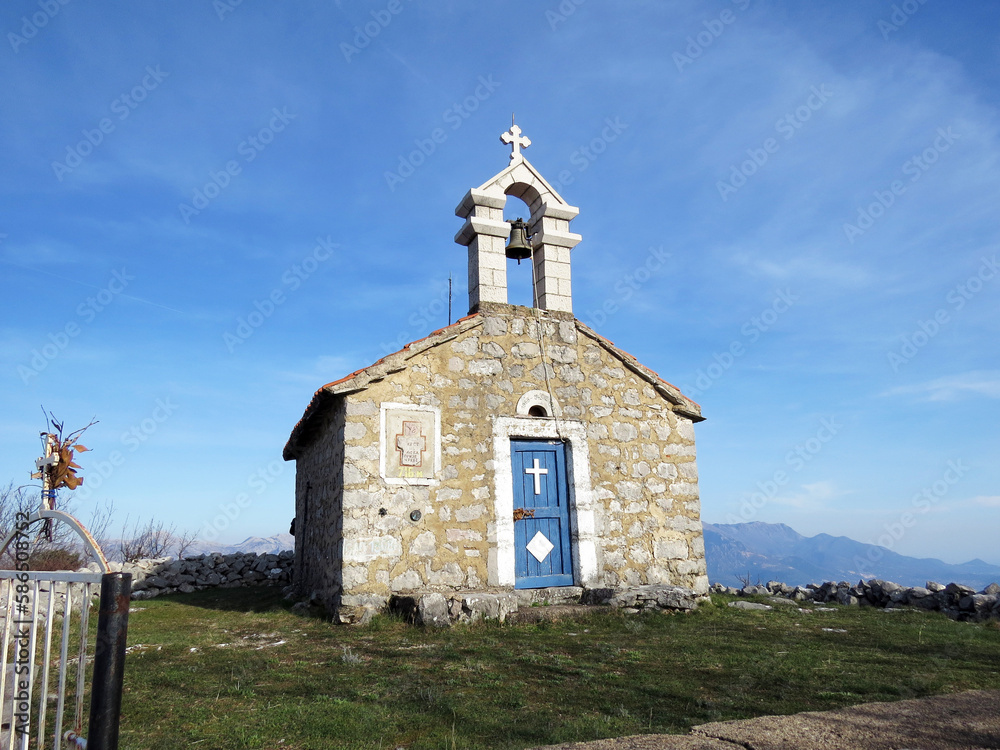 Old stone chapel with crosses and bell in Kotor Bay, Montenegro