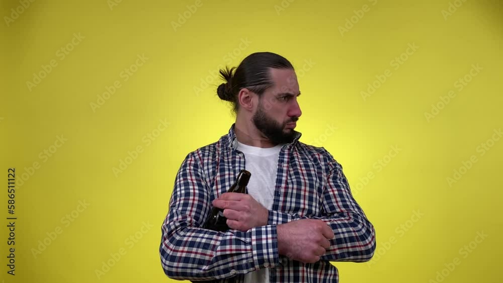 Humorous drunk man appearing suddenly at shot, looking away, someone pushed him out, staggering, hugging bottle, having hiccups. Indoors studio shot isolated on yellow background. Alcoholic addiction Humorous drunk man appearing suddenly at shot, looking away, someone pushed him out, staggering, hugging bottle, having hiccups. Indoors studio shot isolated on yellow background. Alcoholic addiction