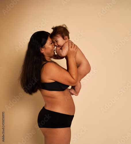 Asian woman in underwear holding a toddler