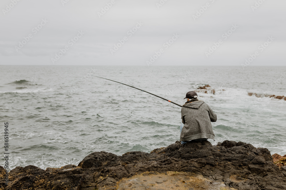 Rear view man fishing in the shore Rear view man fishing in the shore