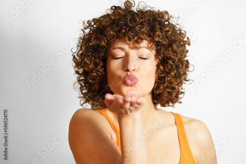 Woman blowing kiss against white background photo