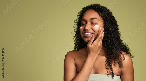Happy black lady smiling while enjoying self care routine after bath