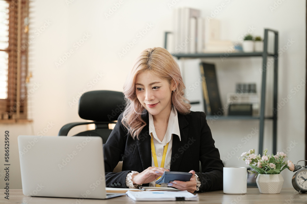 Close up on laptop in office, Asian happy beautiful businesswoman in formal suit work in workplace. Attractive female employee office worker smile.