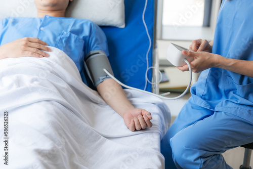 Close up of doctor sitting on bedside of male patient in hospital