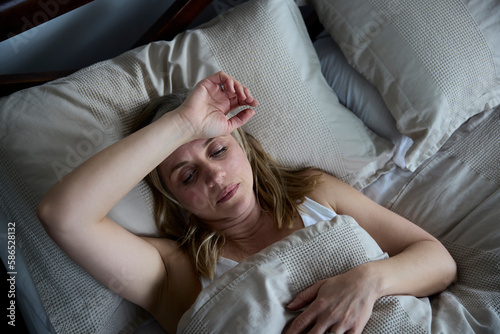 Menopausal Mature Woman Suffering With Insomnia In Bed At Home photo