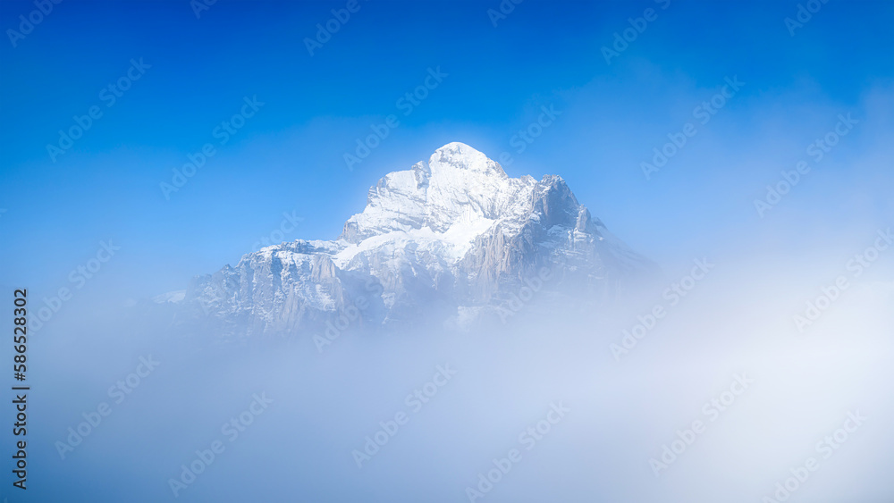 Natural background. Mountains and clouds in the valley. Natural landscape high in the mountains. Mountain range through the clouds.