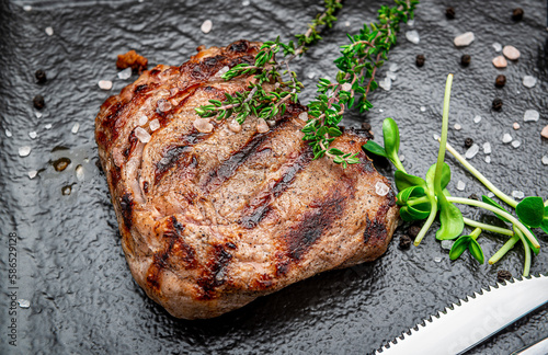 Canvas Print Beef rump steak on black stone table.