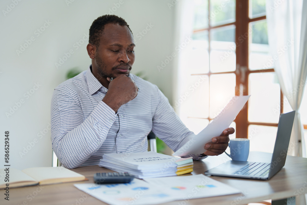 middle aged man American African using computer laptop with planning working on financial document, tax, exchange, accounting and Financial advisor middle aged man American African using computer laptop with planning working on financial document, tax, exchange, accounting and Financial advisor