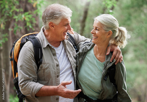 Talking, hiking and happy senior couple on nature adventure in forest, woods and mountain for exercise. Fitness, retirement and elderly man and woman smile, in conversation and trekking for wellness © Nina/peopleimages.com