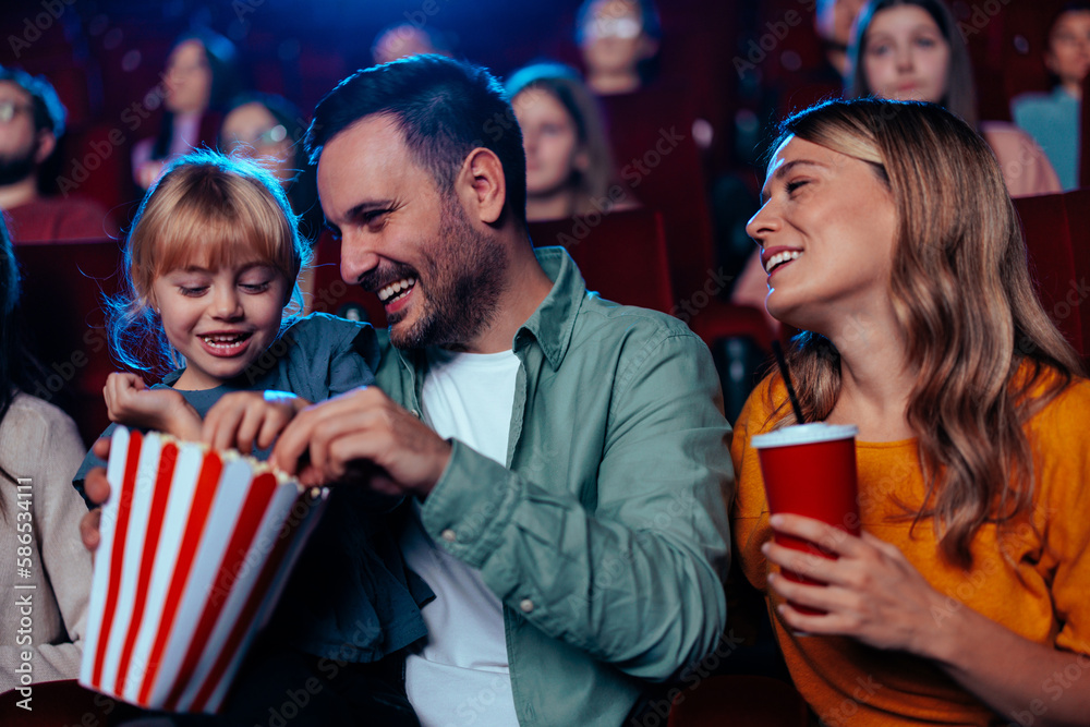 © bernardbodo - Happy parents with child in cinema. © bernardbodo - Happy parents with child in cinema.