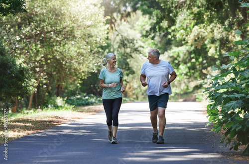 Senior couple, exercise and happy outdoor for a run, workout and training on road for fitness. Elderly man and woman talking about cardio for health and wellness while jogging or running in nature