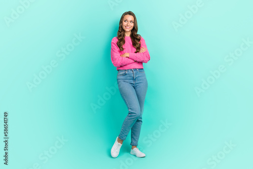 Full length photo of shiny dreamy girl wear pink sweater arms folded looking empty space isolated turquoise color background