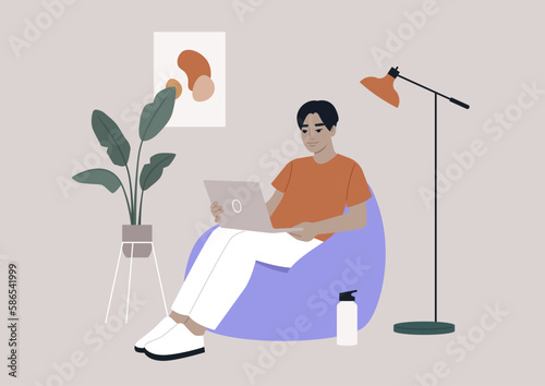 an Asian hipster character sits on a bean bag while typing on their laptop in their home office