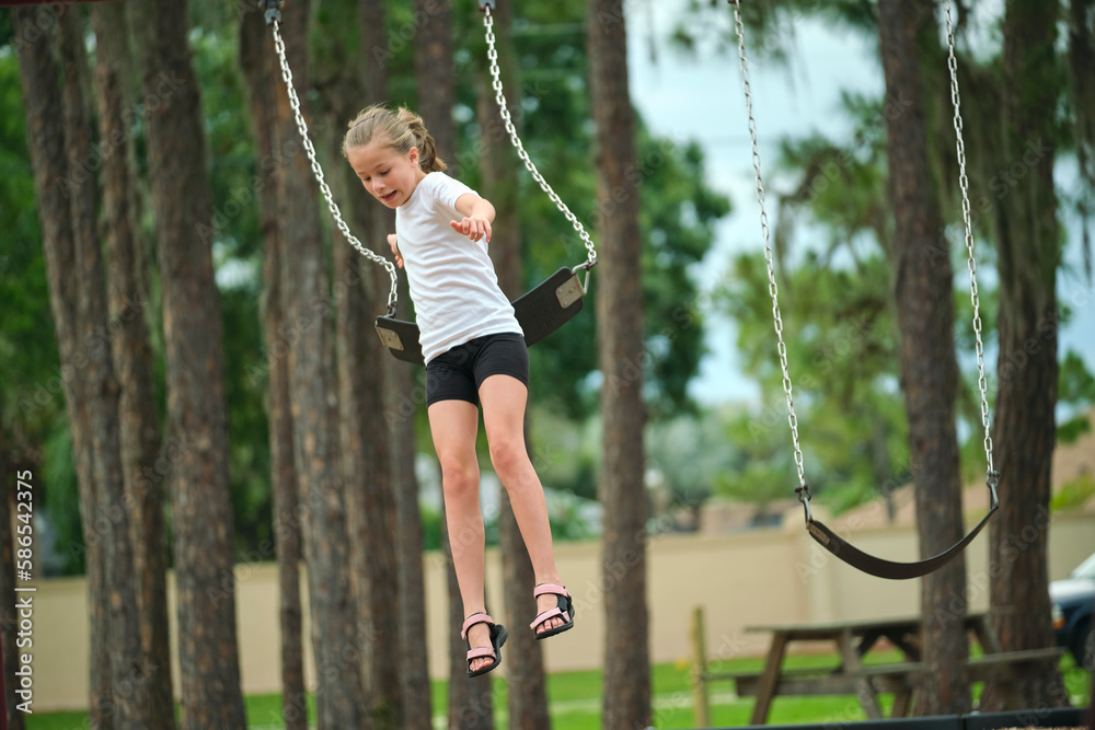 Young pretty excited teenage girl jumping out of the swings on summer vacations sunny day. Danger of accident concept Young pretty excited teenage girl jumping out of the swings on summer vacations sunny day. Danger of accident concept