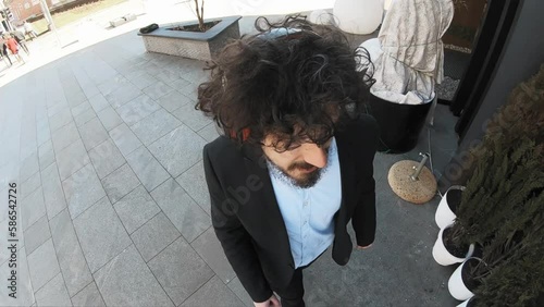 Cheerful and happy businessman in a suit dancing on a street next to business center on a sunny day. Success and business concept. Slow motion photo