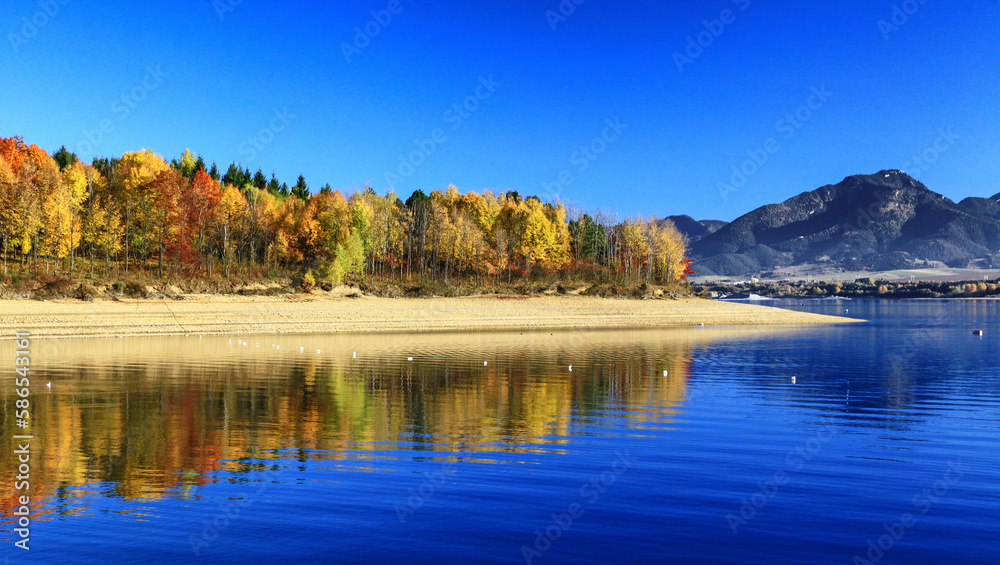 Reflection of colorful autumn trees on water of lake Liptovska Mara in Slovakia