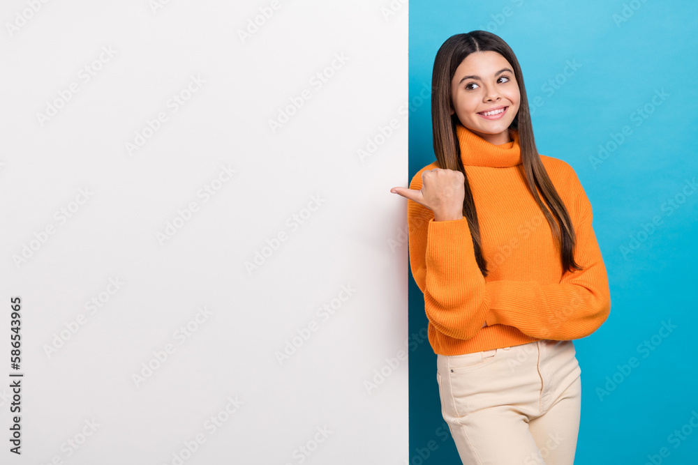 Photo of positive funny girl long hairstyle knit turtleneck hold arms crossed look directing empty space isolated on blue color background Photo of positive funny girl long hairstyle knit turtleneck hold arms crossed look directing empty space isolated on blue color background
