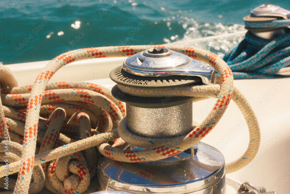 Anchor winch for boats blue rope ropes on the ocean background. Sea travel in summer, adventure, voyage. Ships and yachts details. Pier for mooring. Vintage marina theme. Luxury summertime vacations. Anchor winch for boats blue rope ropes on the ocean background. Sea travel in summer, adventure, voyage. Ships and yachts details. Pier for mooring. Vintage marina theme. Luxury summertime vacations.