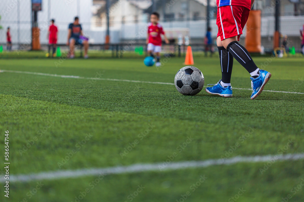 Children playing control soccer ball tactics cone on grass field with for training background Training Children playing control soccer ball tactics cone on grass field with for training background Training