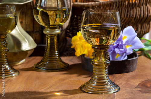 Antique German glassware, old Dutch style rummer or roemer glasses with white wine and flowers photo