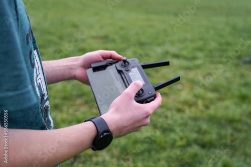 A boy in a field launches a quadcopter and controls it from the remote control.
