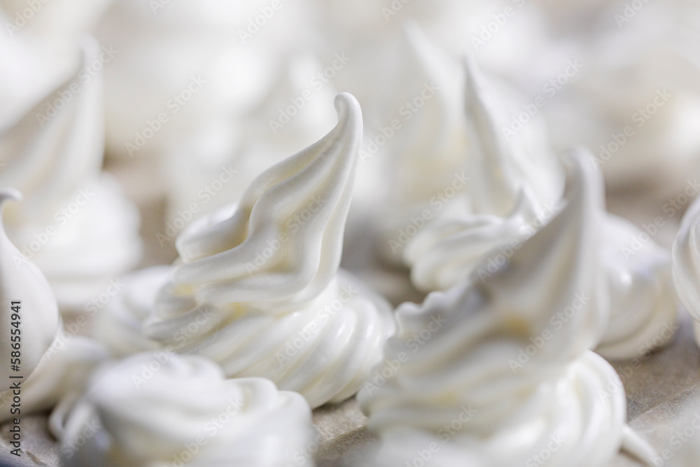 close-up of classic white meringue laid out on foil before baking. Festive mood