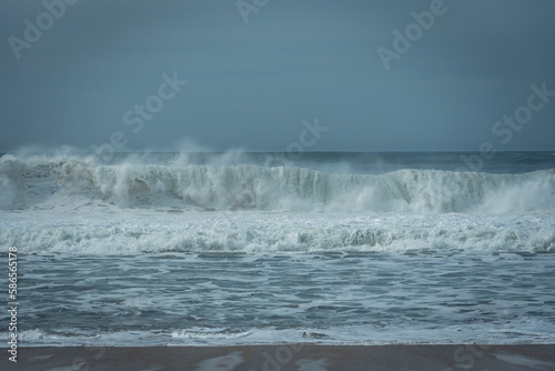 Wind blowing against the waves and misting the foam. Espinho, Portugal