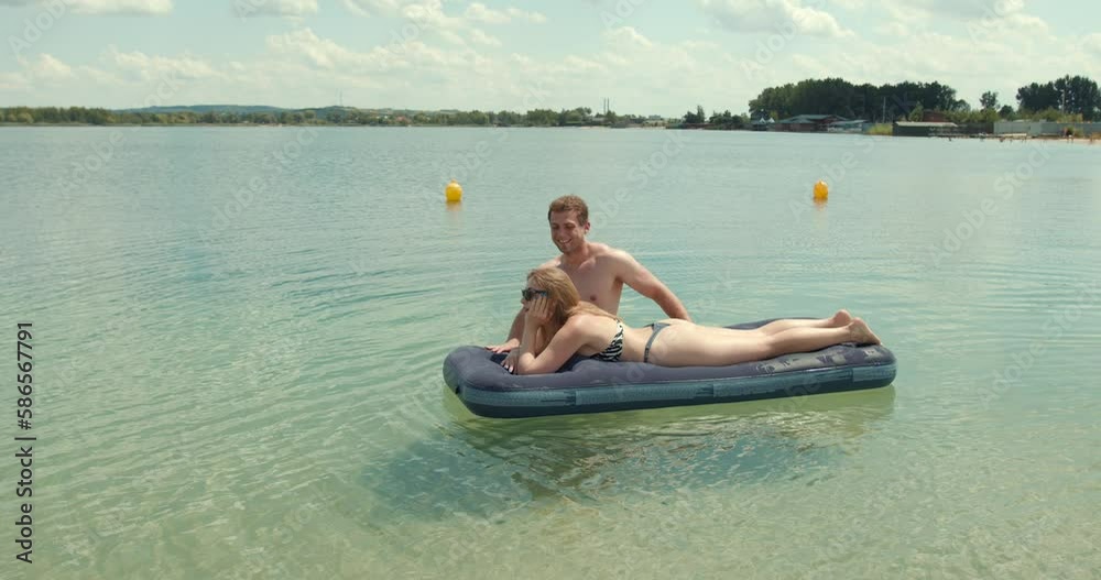 Couple enjoying swimming and sunbathing on a matress Couple enjoying swimming and sunbathing on a matress