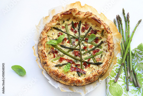 Torta salata con asparagi, ricotta e speck isolati su sfondo bianco. Cibo primaverile. Direttamente sopra. Copia spazio. photo